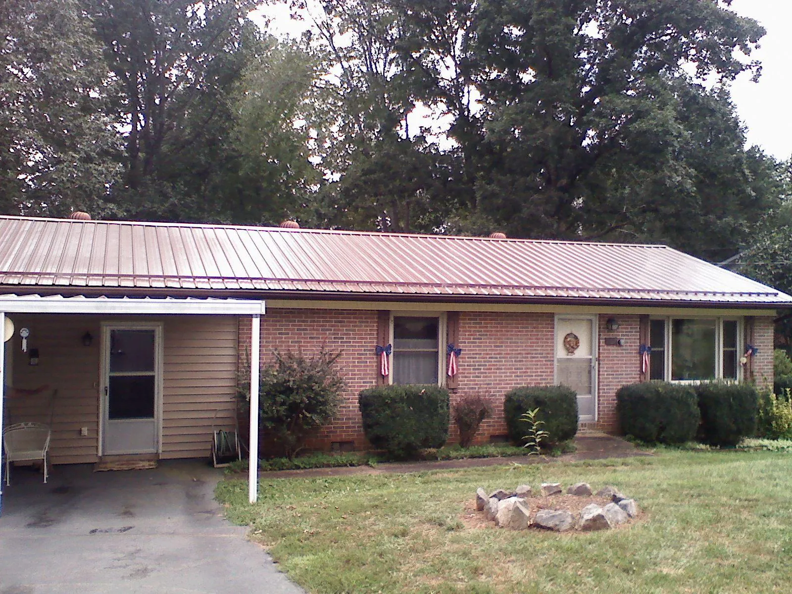 Bronze metal roof and carport on a brick ranch home — Roof Repair work by our crew in Lake Hill